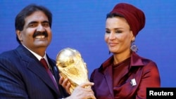 Emir Qatar, Sheikh Hamad bin Khalifa al Thani dan istrinya Sheikha Moza Bint Nasser al-Misnad memegang replika trofi Piala Dunia dari Presiden FIFA Sepp Blatter (unseen) tanda negara itu jadi tuan rumah Piala Dunia 2022. (Foto: Dok)