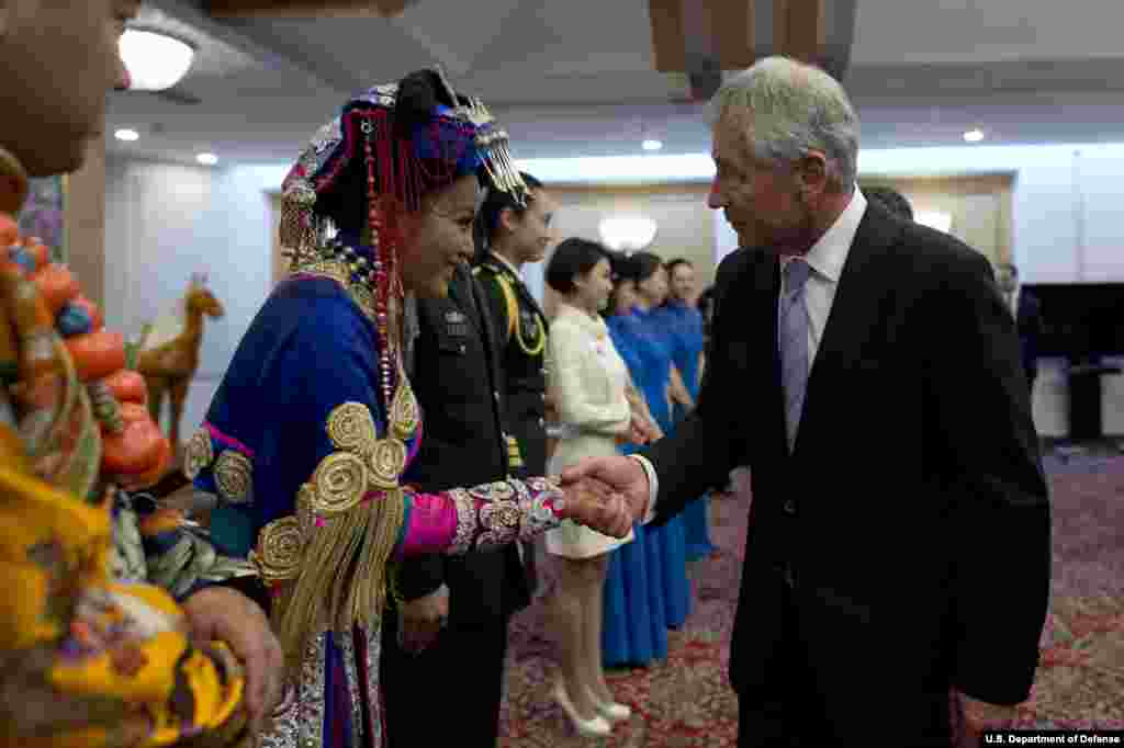 Secretary of Defense Chuck Hagel shakes hands with a traditional Chinese dancer after an official dinner in Beijing, China, April 8, 2014. (Department of Defense)