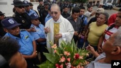 Father Edwin Roman attempts to convince the police to allow relatives of imprisoned and dead anti-government demonstrators to enter the San Miguel Arcangel Church in Masaya, Nicaragua, Nov. 14, 2019. 