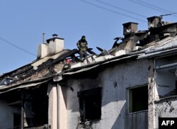 Un rescatista examina el techo de un edificio residencial dañado después del ataque con misiles en la ciudad de Lviv, en el oeste de Ucrania, el 15 de agosto de 2023, en medio de la invasión rusa en Ucrania.