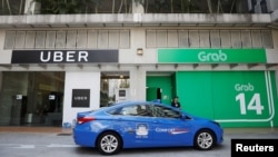 Un taxi pasa frente a las oficinas de Uber y Grab en Sinagapur el lunes, 26 de marzo, de 2018.