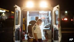 An EMT pauses for a moment while loading a stretcher back into an ambulance after dropping off a patient at a newly opened field hospital operated by Care New England for COVID-19 patients in Cranston, R.I, Tuesday, Dec. 1, 2020. (AP Photo/David…