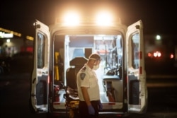 Radnik hitne pomoći zastaje na trenutak prije nego što nastavi sa ubacivanjem nosila nazad u ambulantno vozilo nakon što je prebacio pacijenta u novootvorenu poljsku bolnicu za oboljele od COVID-19, u Cranstonu, 1. decembra 2020. (Foto: AP)