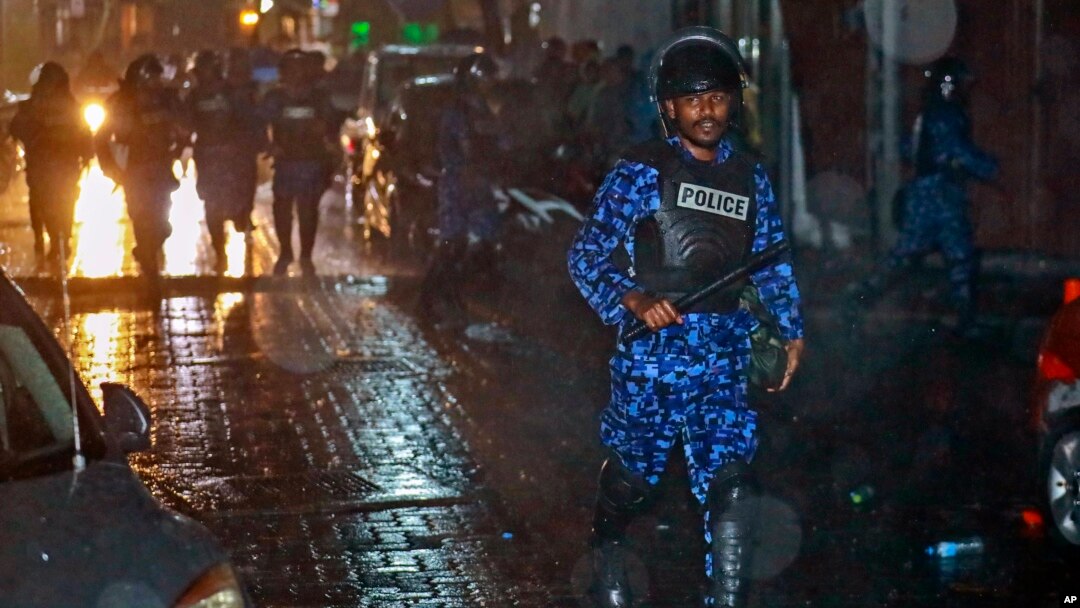 A Maldivian policeman charges with a baton towards protesters after the government declared a state of emergency, in Male, Maldives, Feb. 6, 2018. 