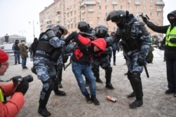 Riot police detain a man during a rally in support of jailed opposition leader Alexei Navalny, in Moscow, Russia, Jan. 31, 2021.