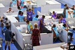 Election office staff and scrutineers work at the Fijian Elections Office National Count Centre in Suva, Fiji, Thursday, Dec. 15, 2022.