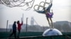 Pengunjung mengambil foto patung figure skater dengan cincin Olimpiade di sebuah taman dekat markas besar Komite Penyelenggara Olimpiade Beijing (BOCOG) di Beijing, Kamis, 18 November 2021.