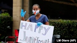 Une femme fait signe de la main lors d'une célébration du 19 juin à Dallas, le vendredi 19 juin 2020. 