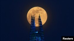 The Pink Supermoon rises over the Shard skyscraper in London in an astronomical event that happens when the Moon is closest to the Earth in its orbit, making it appear much larger and brighter than usual, April 7, 2020.