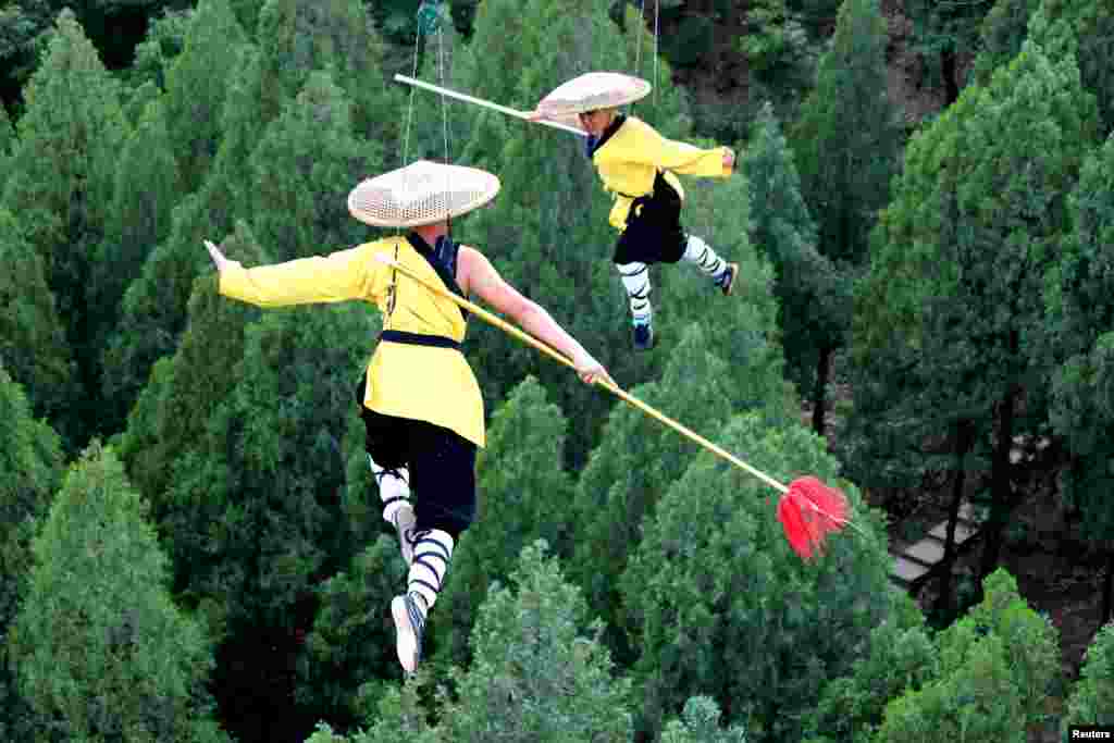 Shaolin martial arts students perform Kung Fu on suspended wires in a rehearsal for a live-action night show in Zhengzhou, Henan province, China, April 28, 2018.