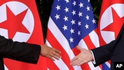 지난 2018년 6월 싱가포르에서 열린 1차 미-북 정상회담에서 도널드 트럼프 미국 대통령(오른쪽)과 김정일 북한 국무위원장이 악수하고 있다.