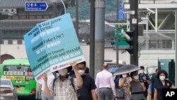 A protester holds a banner opposing planned joint military exercises between South Korea and the United States, near the US Embassy in Seoul, South Korea, Aug. 3, 2021.