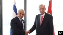 Presiden Turki Recep Tayyip Erdogan (kanan), berjabat tangan dengan PM Israel Yair Lapid selama pertemuan mereka di sela-sela Sidang Umum PBB di New York, AS, Selasa, 20 September 2022 (Kepresidenan Turki via AP)