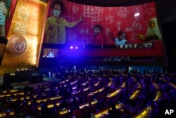 While images are projected on the wall, journalist Folly Ba Thibaut speaks at the start of the Transforming Education Summit at United Nations headquarters, Monday, Sept. 19, 2022. (AP Photo/Seth Wenig)