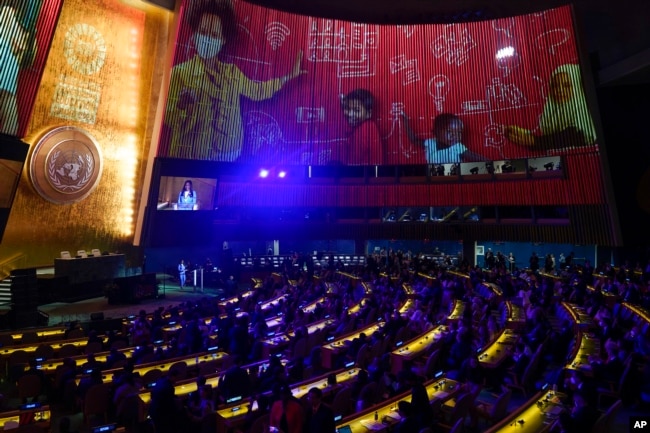 While images are projected on the wall, journalist Folly Ba Thibaut speaks at the start of the Transforming Education Summit at United Nations headquarters, Monday, Sept. 19, 2022. (AP Photo/Seth Wenig)