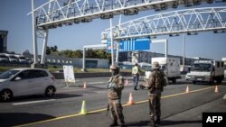 FILE - South Africa soldiers are seen at a checkpoint managed by the South Africa Police Services on the N1 highway in Johannesburg.