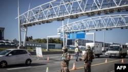 FILE - South Africa soldiers are seen at a checkpoint managed by the South Africa Police Services on the N1 highway in Johannesburg, on Apr. 24, 2020.