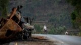 FILE - A man crosses near a destroyed truck on a road leading to the town of Abi Adi, in the Tigray region of northern Ethiopia, May 11, 2021. A spokesman for Tigrayan authorities said Sept 20, 2022, that Eritrea had launched a full-scale offensive along 