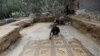 Palestinian farmer Salman al-Nabahin cleans a mosaic floor he discovered at his farm and which dates back to the Byzantine era, according to officials, in the central Gaza Strip, Sept. 18, 2022.