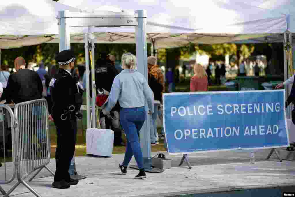 A woman walks by a police security check on arriving at The Long Walk, following the death of Britain&#39;s Queen Elizabeth, in Windsor, Britain, Sept. 18, 2022.