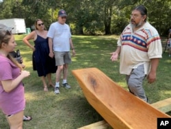 Pedro Zepeda, of the Seminole Tribe of Florida, explains how he and Muscogee elder John John Brown carved a traditional canoe from a cypress tree, Sept. 17, 2002, in Macon, Ga.