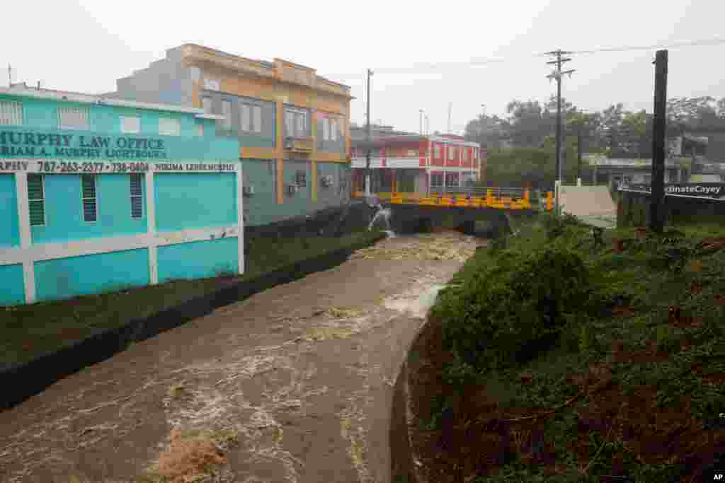 Un río crecido por la lluvia causada por el huracán Fiona atraviesa Cayey, Puerto Rico, el domingo 18 de septiembre de 2022. (Foto AP/Stephanie Rojas)