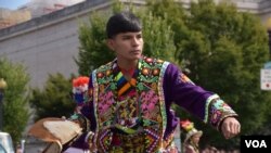 Joven boliviano muestra las acrobáticas danzas y coloridos vestuarios del país andino.  (Foto VOA / Tomás Guevara)