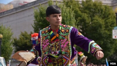 Joven boliviano muestra las acrobáticas danzas y coloridos vestuarios del país andino. (Foto VOA / Tomás Guevara)