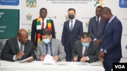 Zimbabwe Mines Minister Winston Chitando, left, participates in the signing of a $2.8 billion investment deal in Harare with officials from
Eagle Canyon International Group Holding Ltd., Sept. 16, 2022. (Columbus Mavhunga/VOA)