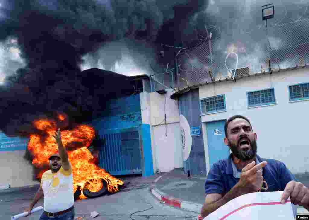 Palestinian people burn tires outside the headquarters of the United Nations Works and Relief Agency (UNRWA)&nbsp;in Gaza City&nbsp;during a protest demanding the UNRWA to rebuild their houses that were destroyed during the Israel-Gaza fighting in 2014.