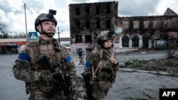 Seorang tentara Ukraina tampak melihat ke atas setelah mendengar suara drone ketika berpatroli bersama rekannya di Kota Kupiansk, wilayah Kharkiv, pada 24 September 2022. (Foto: AFP/Yasuyoshi Chiba)