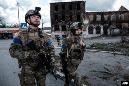 A Ukrainian soldier looks up after hearing a drone during a patrol in the front-line city of Kupiansk, Kharkiv, Sept. 24, 2022.  