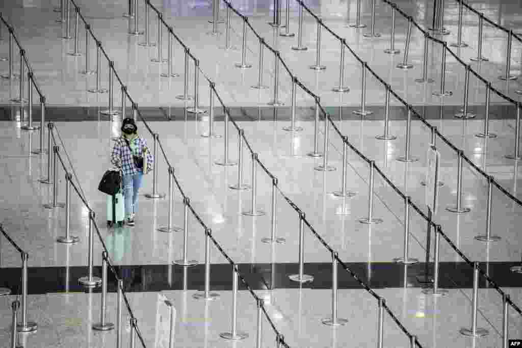 A woman arrives at Hong Kong International Airport before making her way to hotel quarantine. Hong Kong announced on September 23 it will end required hotel quarantine, doing away with some of the world&#39;s most strict travel restrictions.