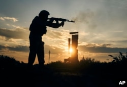 A Ukrainian soldier shoots close to Izium, Kharkiv region, Ukraine, Tuesday, Sept. 13, 2022. (AP Photo/Kostiantyn Liberov)