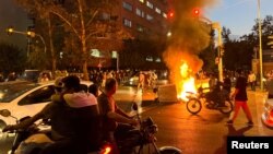 伊朗民眾在德黑蘭焚燒警車，為在伊朗警察局死亡的女子阿米尼（Mahsa Amini）舉行抗議活動。（2022年9月19日）