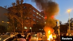 A police motorcycle burns during a protest over the death of Mahsa Amini, a woman who died after being arrested by the Islamic republic's morality police, in Tehran, Iran Sept. 19, 2022. (West Asia News Agency via Reuters)