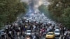 
In this Sept. 21, 2022, photo taken by an individual not employed by the Associated Press and obtained by the AP outside Iran, demonstrators block a street during a protest over the death of a woman who was detained by the country's morality police, in downtown Tehran.
