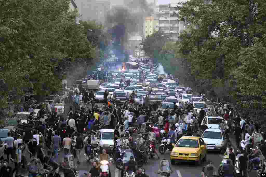 In this Sept. 21, 2022, photo taken by an individual not employed by the Associated Press and obtained by the AP outside Iran, demonstrators block a street during a protest over the death of a woman who was detained by the country&#39;s morality police, in downtown Tehran.