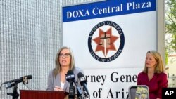 Arizona Secretary of State Latie Hobbs, left, the Democratic nominee for governor, and Kris Mayes, a Democrat running for attorney general, speak to reporters outside the Arizona Attorney General's Office in Phoenix on Sept. 24, 2022. 