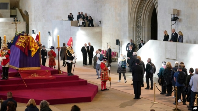 El presidente de los Estados Unidos, Joe Biden, y la primera dama, Jill Biden, en el extremo derecho, ven el ataúd de la reina Isabel II en el catafalco en Westminster Hall, en el Palacio de Westminster, Londres, el 18 de septiembre de 2022.
