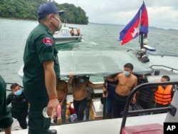 Chinese nationals get off from a speedboat after being rescued from a ship sinking, at an island in Preah Sihanouk Province, southwestern Cambodia on Thursday, Sept. 22, 2022. (Preah Sihanouk province Authority Police via AP)