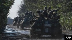 Ukrainian soldiers ride a top of infantry fighting vehicles in Novoselivka, on Sept. 17, 2022, as the Russia-Ukraine war enters its 206th day.