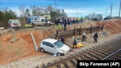 Les services de secours sur les lieux d'un accident de voiture près des voies ferrées près de Salisbury, dans l'État de Caroline du Nord, le mardi 15 mars 2022