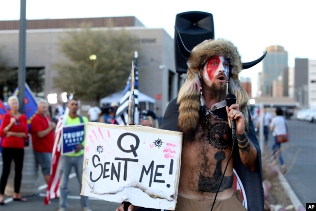 FILE - In this Nov. 5, 2020, file photo, Jacob Anthony Chansley, who also goes by the name Jake Angeli, a Qanon believer, speaks to a crowd of President Donald Trump supporters outside of the Maricopa County Recorder's Office in Phoenix. (AP Photo/Dario Lopez-Mills, File)