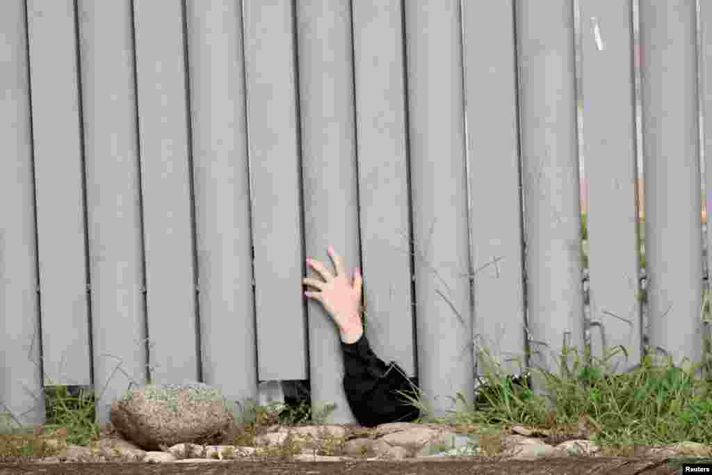 The hand of an Orthodox Jew from Israel, arrested after an operation by agents of the National Institute of Migration (INM), where members of her community who entered the country in the last few weeks were detained, is pictured from outside the INM in Huixtla, in Chiapas state, Mexico, Sept. 25, 2022.