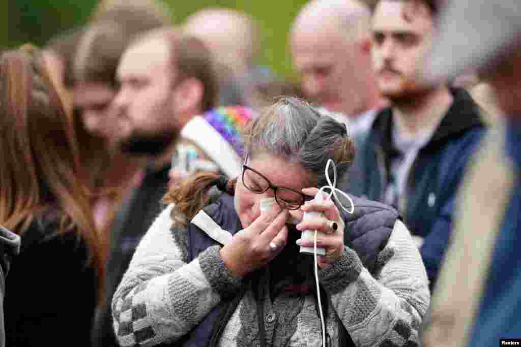 A members of the crowd on The Mall wipes her tears during the State Funeral of Queen Elizabeth at Westminster Abbey in London, Sept. 19, 2022.