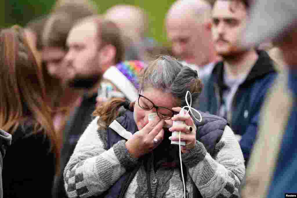 A member of the crowd on The Mall wipes her tears during the State Funeral of Queen Elizabeth at Westminster Abbey in London, Sept. 19, 2022.