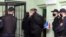 FILE - An opposition activists is escorted to a defendant's cage before a verdict hearing in his trial on charges of organizing riots and inciting social hatred, at a detention center in Gomel, Belarus, Dec. 14, 2021.