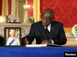FILE - South African President Cyril Ramaphosa signs a book of condolence following the death of Queen Elizabeth II, at Lancaster House in London, Sept. 18, 2022.
