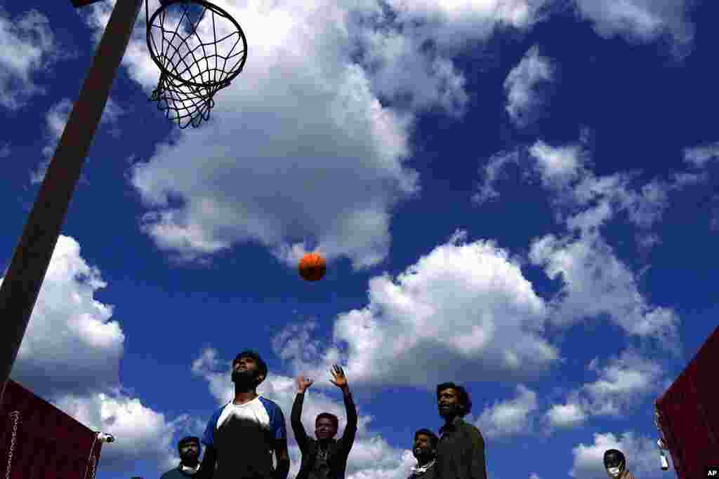 Migrants play basketball on the deck of Spanish NGO Open Arms lifeguard ship as they wait to get off the ship after docking at Messina port, in Sicily, Italy. More than 400 migrants from Egypt, Syria, Pakistan Bangladesh, Eritrea, Sudan, Ethiopia, and Somalia were rescued by NGO Open Arms crew members.&nbsp;